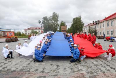 Участники флешмоба «Живой флаг» растянули более 20 метров полотна в цветах российского триколора / Фото Екатерины Эстер
