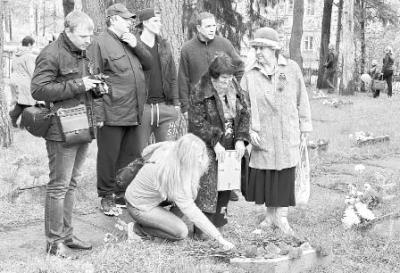 Венера Андрияновна Безумова (в центре) на могиле отца в Новой Ладоге